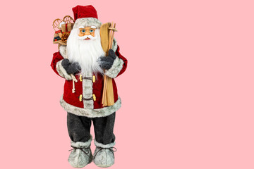 Close up view of cute Santa Clause figure on pink background. Christmas holidays concept.