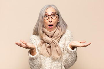 middle age woman open-mouthed and amazed, shocked and astonished with an unbelievable surprise