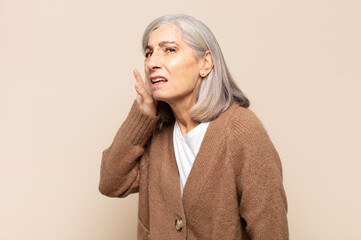 middle age woman looking serious and curious, listening, trying to hear a secret conversation or...