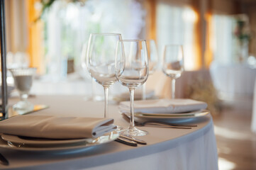 Luxurious restaurant. Luxurious interior, white tables, serving dishes and glasses for guests