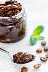 Homemade cosmetics with coffee scrub on white desk background
