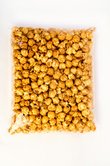 Caramel yellow popcorn in a package on a white background