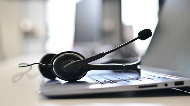 Business woman folds the headset on the laptop keyboard. Close-up of female hands