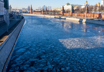 View of the Moskva River with frozen ice floes on the Moskva River after the icebreaker crossing in winter in December. The Moscow Kremlin is visible on the right