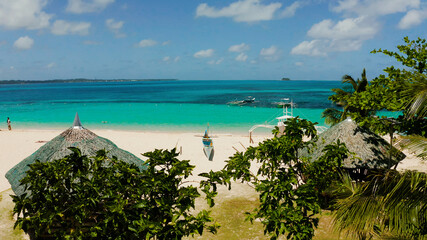 Tropical island with beautiful beach, palm trees and turquoise water view from above. Daco island, Philippines. Summer and travel vacation concept