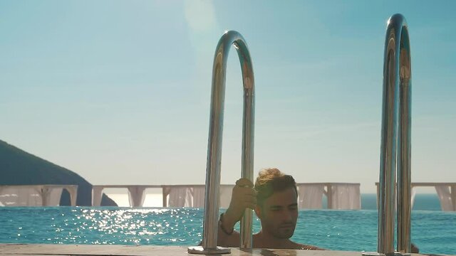 man comes out of the pool on the stairs