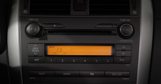 Listening to music inserting CD in a car, turning up the volume for selected favorite song