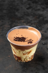 Banoffee pie dessert in cup with fresh banana on wooden background, selective focus, copy space
