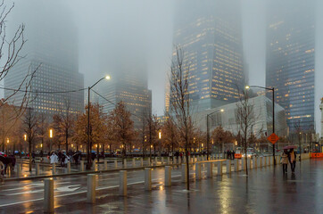 Low Angle View of Lower Manhattan Skyscrapers on a Foggy Night in New York City, USA. Rainy Weather...