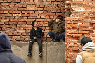 two little street boys sit having fun outdoors, they are not sad despite their social position, never give up. homeless people