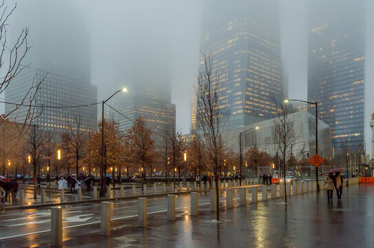 Low Angle View of Lower Manhattan Skyscrapers on a Foggy Night in New York City, USA. Rainy Weather in a Square in Financial District