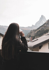 woman drinking coffee and looking at the mountain