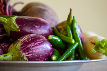 View of multi-colored vegetables ( chili pepper, brinjal, radish, beetroot) in a bowl plate