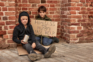 two poor kids needs shelter and food food donation from strangers, on street in big city, begging. shelter concept.