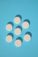 Top view of white rounded drugs isolated on blue background. Mock-up.