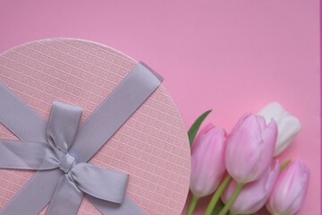 tulips flowers.International Women's Day, Mother's Day festive background.Floral card blank with white and pink tulips and a round box with a bow on a light pink background.copy space