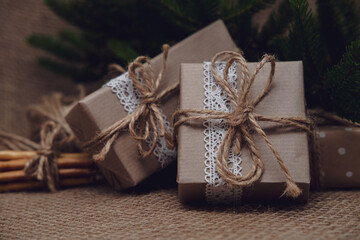 Fototapeta na wymiar Xmas gifts on jute background. Zero waste gift packaging and holiday decoration concept