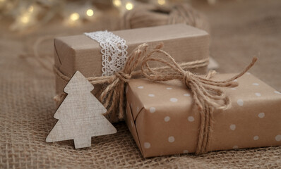 Fototapeta na wymiar Winter holidays gift boxes on jute background. Eco friendly and zero waste gift packaging