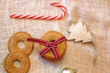 Fototapeta na wymiar Biscuits tied with red ribbon and Christmas decorations. Top view.