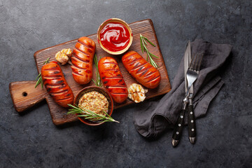 Hot grilled sausages on wooden board
