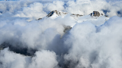 Panoramic view of the winter mountain snowy peaks over the clouds near Wengen village in Switzerland.