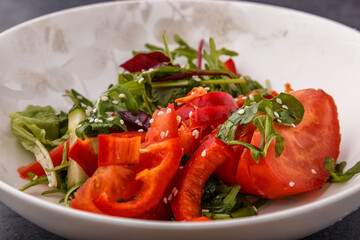 Vegan Spring Salad. Tomato, lettuce, dressing, bell peppers and avocados. Fork with vegetables and salad.