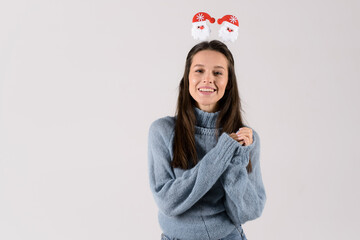 Photo of an excited young woman in blue sweater pullover wearing funny christmas head hoop isolated over grey background