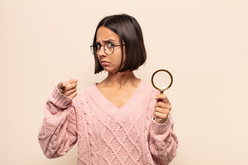 young hispanic woman pointing forward at camera with both fingers and angry expression, telling you...