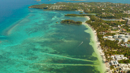 Tropical beach with turquoise water on which kite-surfer rides, aerial view. Kitesurfing on a...