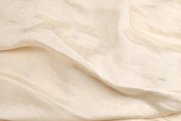 Soft smooth beige silk fabric background. Fabric texture.