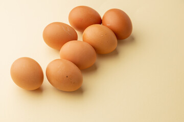 brown chicken eggs on color background