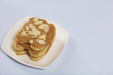 Eclairs cake smeared with cinnamon cream. On a white surface.