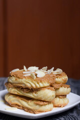 Eclairs cake smeared with cinnamon cream. On black pine boards.
