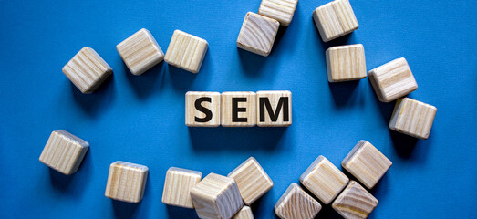 SEM symbol. Concept word 'SEM - search engine marketing' on wooden cubes on a beautiful blue background. Business and search engine marketing - SEM concept. Copy space.