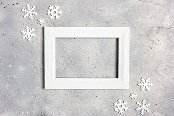 Photo frame and snowflakes on gray stone background