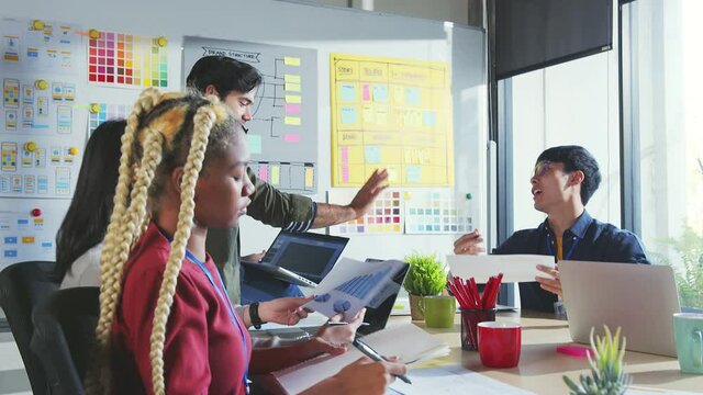 Meeting of UX developer and UI designer brainstorming about mobile app interface workflow design on table with coworker breif and color code at co-working space.Creative digital development agency.