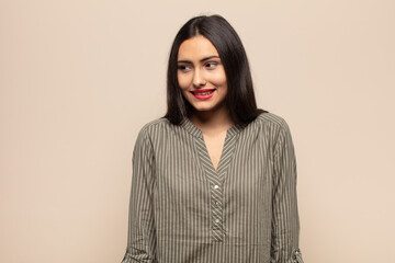 young hispanic woman looking puzzled and confused, biting lip with a nervous gesture, not knowing...