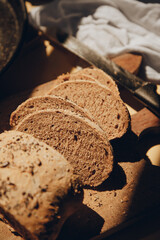 Integral flour homemade bread with seeds, cut into slices on wood plank