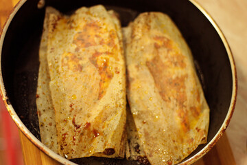 Chicken roasted in paper on black pan