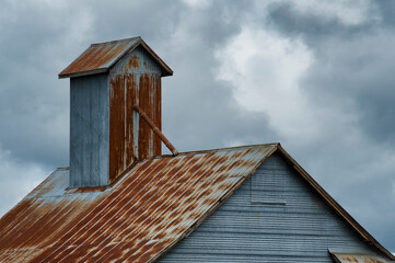 Barn roof top under stormy skies