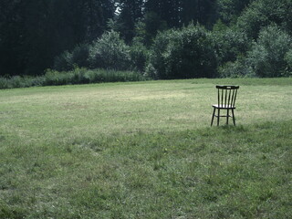 Still life with a lone chair in the meadow