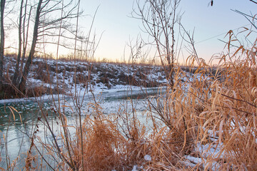 Colourful landscape with snowy trees, beautiful frozen river.