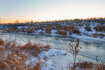Fototapeta premium Colourful landscape with snowy trees, beautiful frozen river.