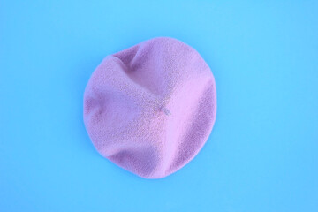 Lilac wool beret on a blue background.