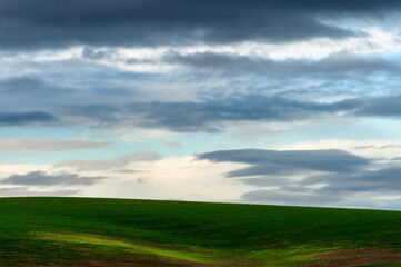 Minimalist of rolling agriculture field under cloudy skies