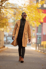 Fashion portrait of stylish African American man walking in the autumn city