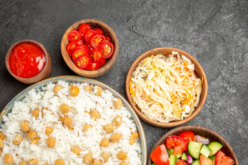 Top view of peas and rice meal sauerkraut salad mayonnaise spices and ketchup on dark table
