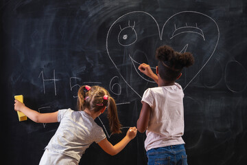Little girls drawing on chalkboard during a break between classes