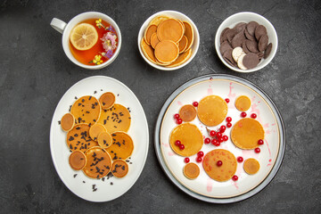 top view yummy pancakes with cup of tea on a dark background sweet pie dessert cake