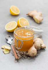 Marmalade lemon ginger in a jar on a linen napkin on a light gray background